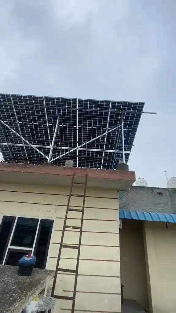 Solar panels being fitted on a house roof in Punjab, a ladder against the wall