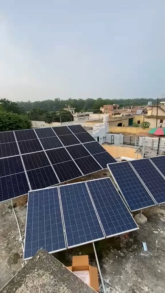 Rooftop solar array on a house in Punjab, the panels raised on a steel frame above the roof slab