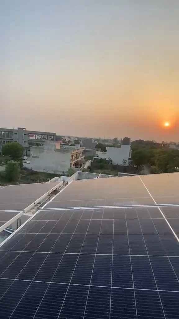 Rooftop solar panels on a building with a town behind them