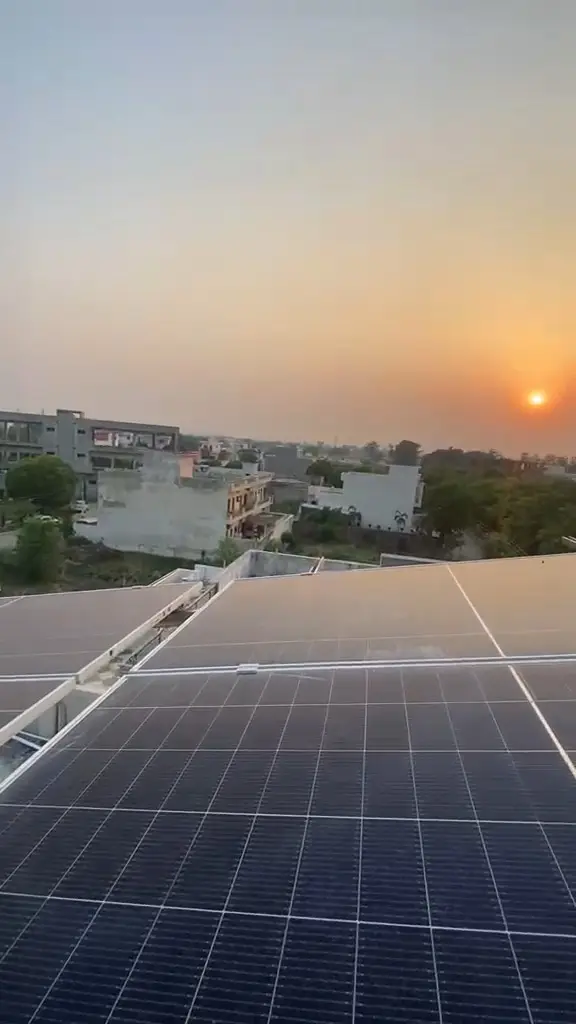 Rooftop solar panels on a building with a town behind them