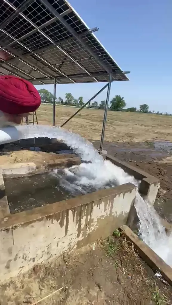 Water flowing from a solar pump into a concrete field channel in Punjab