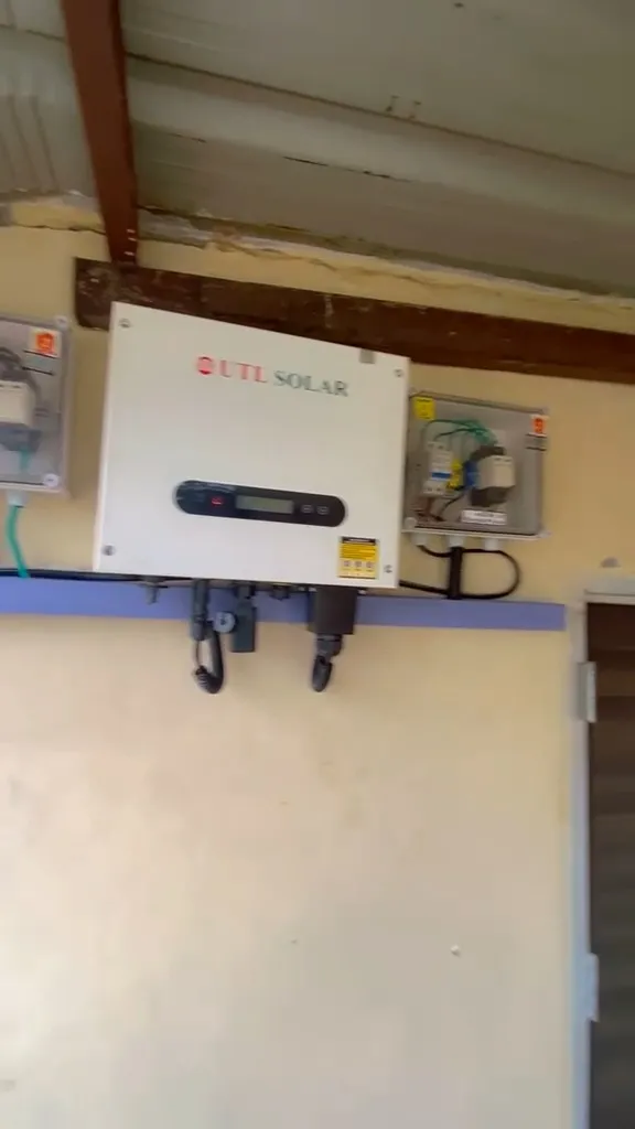 UTL Solar inverter mounted on the wall of a pump house, with conduit running out to the array